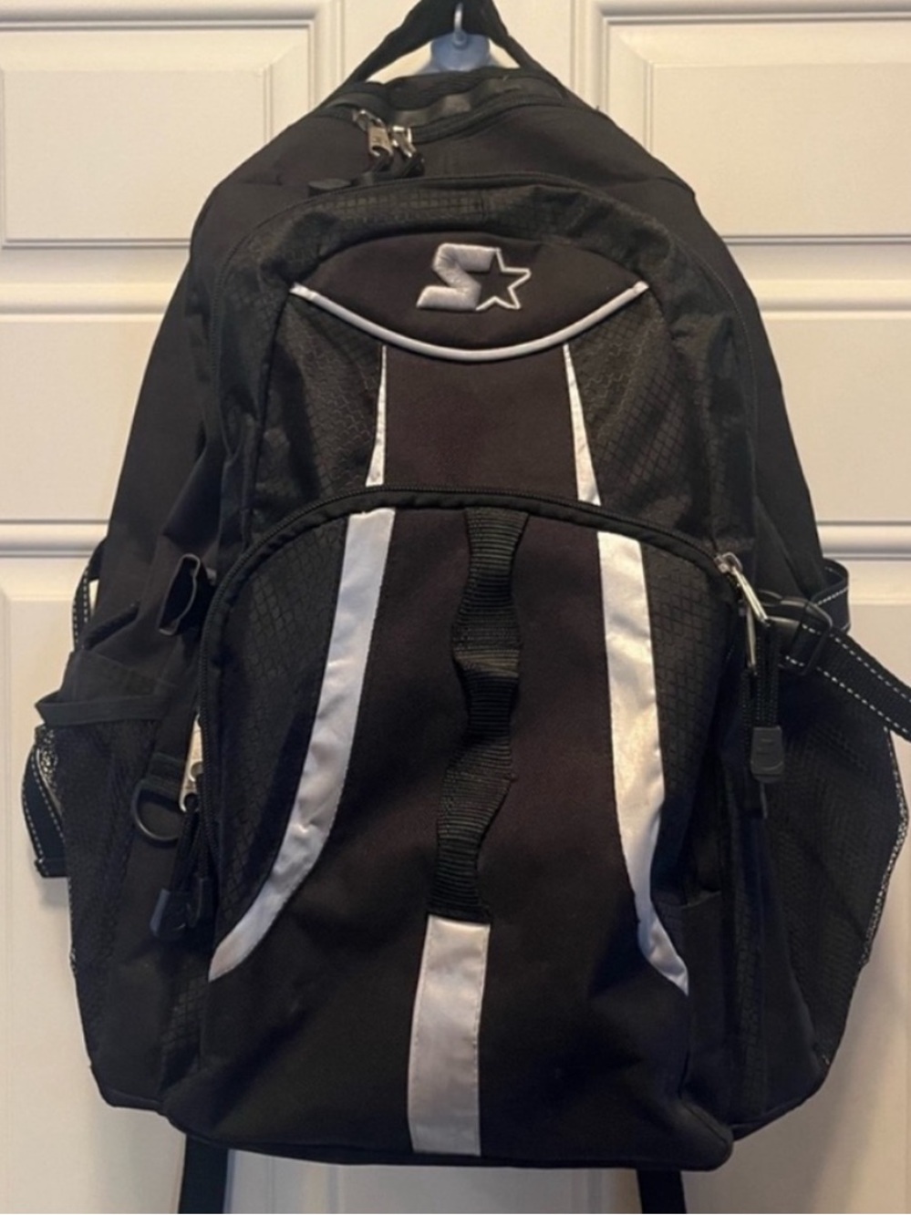 Starter black backpack . Includes multiple compartments and mesh side pockets.